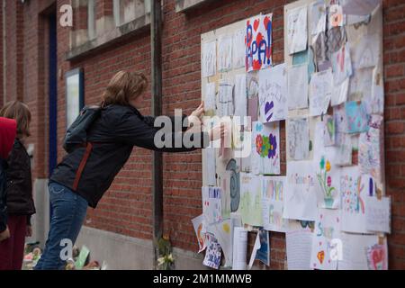 20120316 - HEVERLEE, BELGIEN: Abbildung zeigt eine Frau, die eine Zeichnung an die Wand der Grundschule (Basisschool - ecole Primaire) Sint-Lambertusschool, in Heverlee, Freitag, den 16. März 2012, klebt. Bei einem schrecklichen Busunfall am Dienstagabend in einem Tunnel, in Sierre, Valais, Schweiz, 28 Menschen, Darunter 22 Kinder, starben, 24 andere wurden verletzt. Die Kinder aus zwei Schulen von Lommel und Heverlee waren nach dem Skiurlaub auf dem Heimweg. BELGA FOTO CHRISTOPHE LEGASSE Stockfoto