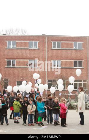 20120316 Uhr - HEVERLEE, BELGIEN: Kinder, die während der Schweigeminute am Tag der belgischen Trauer um die Grundschule (Basisschool - ecole Primaire) Sint-Lambertusschool in Heverlee, Freitag, den 16. März 2012, Ballons in der Luft lassen. Bei einem schrecklichen Busunfall am Dienstagabend in einem Tunnel, in Sierre, Valais, Schweiz, 28 Menschen, Darunter 22 Kinder, starben, 24 andere wurden verletzt. Die Kinder aus zwei Schulen von Lommel und Heverlee waren nach dem Skiurlaub auf dem Heimweg. BELGA FOTO CHRISTOPHE LEGASSE Stockfoto