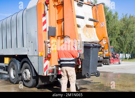 Arbeiter des städtischen Müllsammelwagens zum Verladen von Müll und Müll Stockfoto