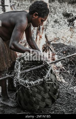 Der Korowai-Stamm fängt Fische mit Fallen, indem er Körbe aus Sagoblättern mit Gras und Holztermiten verwendet. Der Korb wird dann "imm" sein Stockfoto