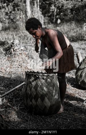 Der Korowai-Stamm fängt Fische mit Fallen, indem er Körbe aus Sagoblättern mit Gras und Holztermiten verwendet. Der Korb wird dann "imm" sein Stockfoto