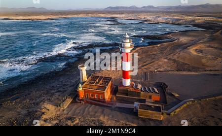 Meereslandschaft mit Leuchtturm bei Sonnenuntergang. Luftaufnahme von der Drohne, Fuerteventura. Kanarische Insel, Dorf El Cotilio. Der Leuchtturm von El Toston Stockfoto