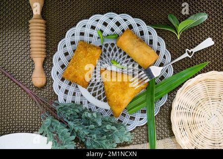 Rougut, Lumpia und Risol geräuchertes Rindfleisch, traditionelles indonesisches Essen auf weißem Teller Stockfoto