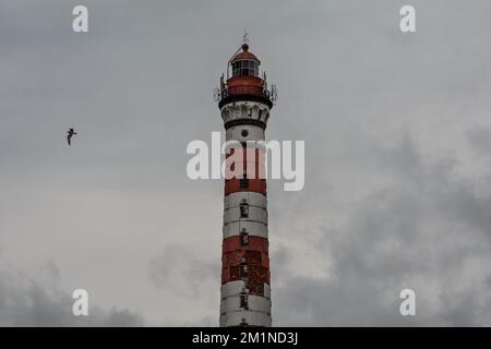 Hoher Leuchtturm bei bewölktem Wetter. Weiß-roter Leuchtturm. Osinovets Leuchtturm, Lake Ladoga Stockfoto