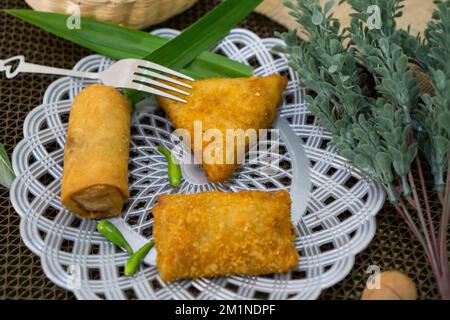 Rougut, Lumpia und Risol geräuchertes Rindfleisch, traditionelles indonesisches Essen auf weißem Teller Stockfoto