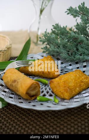 Rougut, Lumpia und Risol geräuchertes Rindfleisch, traditionelles indonesisches Essen auf weißem Teller Stockfoto