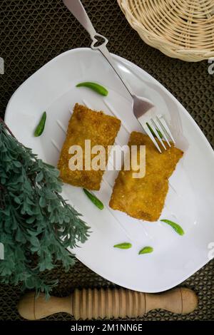 Rougut, Lumpia und Risol geräuchertes Rindfleisch, traditionelles indonesisches Essen auf weißem Teller Stockfoto