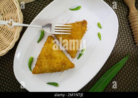 Rougut, Lumpia und Risol geräuchertes Rindfleisch, traditionelles indonesisches Essen auf weißem Teller Stockfoto