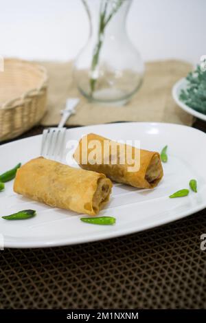 Rougut, Lumpia und Risol geräuchertes Rindfleisch, traditionelles indonesisches Essen auf weißem Teller Stockfoto