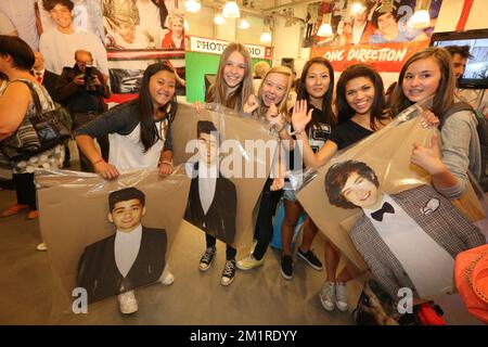 Fans posierten mit Zayn Malik und Harry Styles während der Eröffnung eines provisorischen Ladens, das Merchandising der britisch-irischen Boyband One Direction am Freitag, den 16. August 2013, im Waasland Shopping Center in Sint-Niklaas verkaufte. Das Einkaufszentrum stellte zusätzliche Sicherheitsmaßnahmen aus, um die Fans der Band zu empfangen. Stockfoto