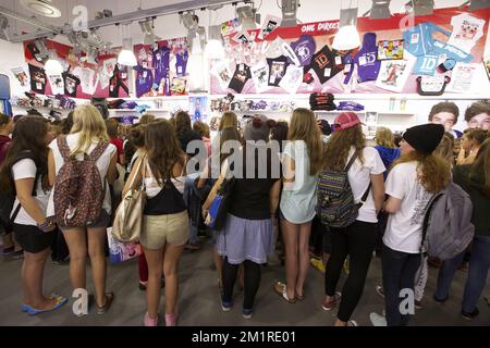 Das Abbildungsbild zeigt Fans während der Eröffnung eines temporären Ladens, das Merchandising von einer britisch-irischen Boyband One Direction am Freitag, den 16. August 2013, im Waasland Shopping Center in Sint-Niklaas verkauft. Das Einkaufszentrum stellte zusätzliche Sicherheitsmaßnahmen aus, um die Fans der Band zu empfangen. Stockfoto