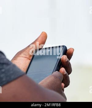 Afrikanischer Geschäftsmann mit schwarzem Smartphone Stockfoto