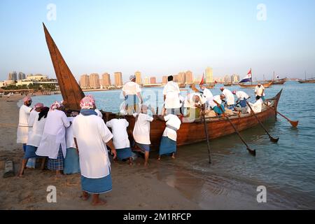 Einheimische Arbeiter drängen ein Boot im Katara Cultural Village in Doha, Katar. Foto: Dienstag, 13. Dezember 2022. Stockfoto