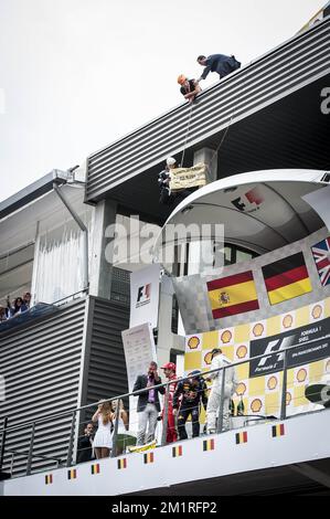 Abbildung zeigt eine Aktion von Greenpeace auf dem Podium des spanischen Fernando Alonso von Ferrari, des deutschen Sebastian Vettel von Red Bull Racing und des britischen Lewis Hamilton von Mercedes nach dem Großen Preis F1 von Belgien, in Spa-Francorchamps, Sonntag, 25. August 2013. Der Spa-Francorchamps Formel 1 Grand Prix findet an diesem Wochenende vom 23. August bis 25. August statt. BELGA FOTO ERIC LALMAND Stockfoto