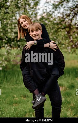 Ivano-Frankivsk, Ukraine 15. Mai 2021 : Porträts von Kindern im Teenageralter in schwarzer Kleidung, einem Jungen, der einen Klassenkameraden auf den Schultern hält. Stockfoto