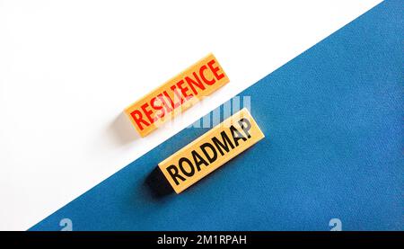 Roadmap-Symbol für Resilienz. Konzeptbegriff „Resilience“-Roadmap auf Holzblöcken getippt. Schöner weißer und blauer Papierhintergrund. Business und Resilienz Stockfoto