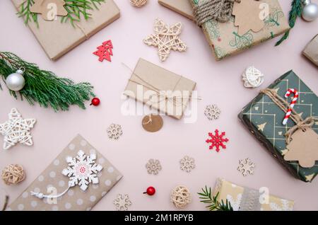 Umweltfreundliche Weihnachtsgestaltung mit Geschenkboxen aus wiederverwendbarem Papier und natürlicher Einrichtung auf weißem Hintergrund, Draufsicht. Keine Umweltverschwendung Stockfoto