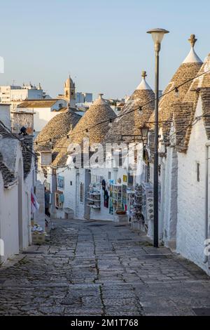 Weiß getünchte Trulli Häuser entlang der Straße in der Altstadt, Alberobello, Apulien, Italien, Europa Stockfoto