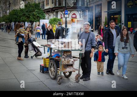 Sevilla, Spanien; 6. Dezember 2022: . Kastanienverkäufer in einer Straße von Sevilla Stockfoto