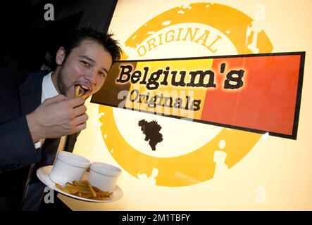 20131204 – HONGKONG, CHINA: Belgischer Betriebsleiter der Original Ltd, Waedong, isst während der Eröffnungszeremonie des belgischen Restaurants Originals in Hongkong am zweiten Tag einer Wirtschaftsmission anlässlich der Veranstaltung „Hong Kong Business of Design Week (BoDW)“ in Hongkong belgische Pommes frites. Sonderverwaltungsregion der Volksrepublik China, Mittwoch, 04. Dezember 2013. Zu Königin Mathilde von Belgien kommen Minister der verschiedenen Regionen. BELGA FOTO BENOIT DOPPPAGNE Stockfoto