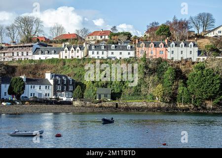 Blick über kleine Boote im Hafen bei den Häusern von Portree an der Klippe auf der Isle of Skye. Stockfoto