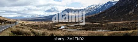 Blick auf die Berge, die Straße und das Tal auf dem Gipfel von Glencoe im Hochland Schottlands. Stockfoto