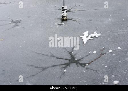 Zerbrochenes, dünnes Eis auf einem gefrorenen Teich. UK Stockfoto