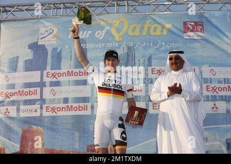 20140213 Uhr - AL ZUBARA FORT, KATAR: Deutscher Andre Greipel von Lotto - Belisol feiert auf dem Podium nach dem Sieg der fünften Etappe des Radrennen der Katar Tour 2014, 159 km von Al Zubara Fort nach Madinat Al Shamal, Katar, Donnerstag, 13. Februar 2014. Die Katar Tour 2014 findet vom 9. Bis 14. Februar statt. Stockfoto