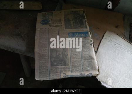 Verbranntes Notizbuch über braunen Herbstblättern, die in der nuklearen Katastrophenschutzzone tschernobyl auf dem Boden lagen Stockfoto