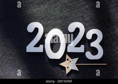 2023 Neujahrskarte mit großen Holzbuchstaben und Kopierfeld. Weißes gestrichenes Holz schuf die Aufschrift Nr. 2023 auf schwarzem Hintergrund. Stockfoto