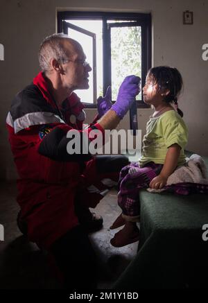 20150430 Uhr - GORKHA, NEPAL: Ein B-Fast-Team kümmert sich um ein lokales Kind, eine Soforthilfemission des belgischen B-Fast-Katastrophenhilfeteams in Gorkha (140 km von Kathmandu entfernt), Nepal, Donnerstag, 30. April 2015. Nepal wurde am Samstag, den 25. April, von einem Erdbeben heimgesucht, das massive Schäden in der Hauptstadt Kathmandu und Lawinen im Basislager des Everest verursachte. Mehr als 5000 Menschen sind nachweislich gestorben. BELGA FOTO BENOIT DOPPPAGNE Stockfoto