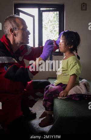 20150430 Uhr - GORKHA, NEPAL: Ein B-Fast-Team kümmert sich um ein lokales Kind, eine Soforthilfemission des belgischen B-Fast-Katastrophenhilfeteams in Gorkha (140 km von Kathmandu entfernt), Nepal, Donnerstag, 30. April 2015. Nepal wurde am Samstag, den 25. April, von einem Erdbeben heimgesucht, das massive Schäden in der Hauptstadt Kathmandu und Lawinen im Basislager des Everest verursachte. Mehr als 5000 Menschen sind nachweislich gestorben. BELGA FOTO BENOIT DOPPPAGNE Stockfoto