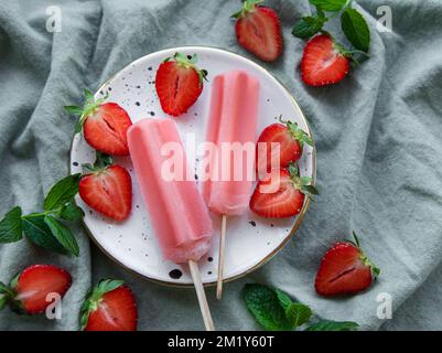Hausgemachte gefrorene Erdbeer-Eiscreme, Eiszapfen und frische Erdbeeren. Sommerdessert Stockfoto