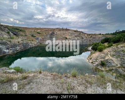 Der reflektierende Emerald Lake of Racos von einem oberen Pfad aus mit dem wolkigen Himmel über Rumänien Stockfoto