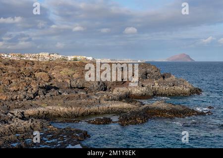 Felsige Ufer und tiefblaues Wasser, in der Nähe des zerklüfteten vulkanischen Wanderwegs, der das Naturdenkmal Montana Amarilla und das Golfdorf Amarilla verbindet Stockfoto