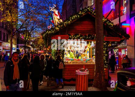 Der beliebte Weihnachtsmarkt und die Lichter von Frankfurt, Birmingham, West Midlands, England, sind im Winter nachts in der New Street zu finden Stockfoto