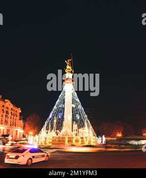 Tiflis, Georgien - 12.. dezember 2021: Polizeifahrzeug steht im Kreisverkehr auf der Straße und fährt am Kreisverkehr vorbei an Autos in Freedom Swaure auf C Stockfoto