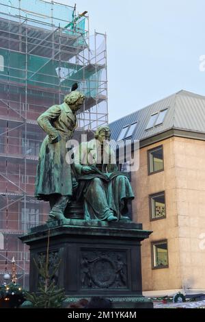 Hanau, Deutschland - 15. Dezember 2019: Brüder Grimm Statue mit schwarzem Vogel auf dem Kopf in Hanau. Stockfoto