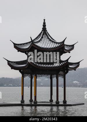 Ein vertikaler Blick auf den Pavillon am Westsee, umgeben von Hügeln während des Tages in Hangzhou, Ostchina Stockfoto