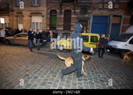 Polizei mit Hunden außerhalb des Sicherheitsbereichs um die Karperstraat - Rue de la Carpe, wo mehrere Einwohner auf den Straßen stehen, Teil mehrerer Polizeiaktionen in Sint-Jans-Molenbeek - Molenbeek-Saint-Jean, Brüssel, Freitag, 18. März 2016. Salah Abdeslam wurde gestern bei den Durchsuchungen in der Rue des Quatre-vents - Vierwindenstraat festgenommen. Er gilt als einer der Hauptverdächtigen bei den Terroranschlägen in Paris vom 13.. November und bei der Schießerei am Dienstag in Vorst. Stockfoto