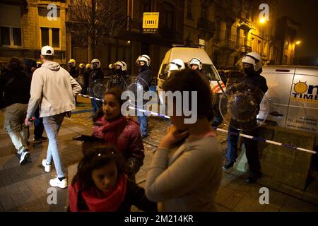 Journalist und Einwohner (einschließlich Kinder), wie die Polizei einen Sicherheitsbereich um die Karperstraat - Rue de la Carpe, Teil mehrerer Polizeiaktionen in Sint-Jans-Molenbeek - Molenbeek-Saint-Jean, Brüssel, Freitag, 18. März 2016, errichtete. Salah Abdeslam wurde gestern bei den Durchsuchungen in der Rue des Quatre-vents - Vierwindenstraat festgenommen. Er gilt als einer der Hauptverdächtigen bei den Terroranschlägen in Paris vom 13.. November und bei der Schießerei am Dienstag in Vorst. Stockfoto