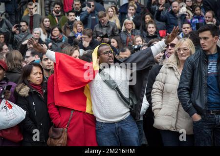 Abbildung zeigt einen Mann mit belgischer Flagge am Place de la Bourse - Beursplein in Brüssel, Mittwoch, den 23. März 2016. Gestern Vormittag explodierten zwei Bomben in der Abflughalle des Brüsseler Flughafens und eine weitere in der U-Bahn-Station Maelbeek - Maalbeek, die rund 30 Tote und insgesamt 230 Verletzte forderte. ISIL (Islamischer Staat Irak und die Levante - Daesh) hat sich für diese Angriffe verantwortlich gemacht. Die terroristische Bedrohung wurde landesweit auf vier erhöht. Stockfoto