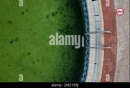 Blick auf einen verlassenen Swimmingpool. Poll Lader grünes Schmutzwasser Stockfoto