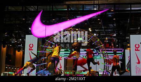 Paris, Frankreich - November 29,2022: Nahaufnahme des Schaufensters des Nike Stores bei Nacht mit Neonlicht-Logo Stockfoto