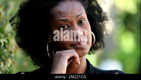 Eine zweifelhafte afrikanische schwarze Frau, die in die Kamera schaut, eine unsichere skeptische Person Stockfoto