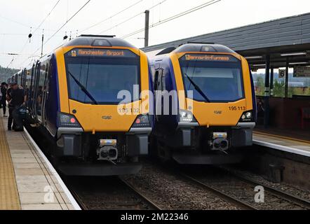 Im September 2022 verkehren zwei Northern DMU-Züge in Wigan North Western, einer mit einem Barrow-Service zum Flughafen Manchester und einer in die entgegengesetzte Richtung Stockfoto