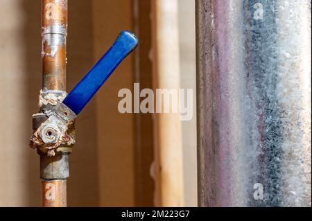 Korrosion an einem festsitzenden Kugelventil aufgrund von Undichtigkeiten und Kondensat aus heißem Wasser in Rohren und kalter Luft. Stockfoto