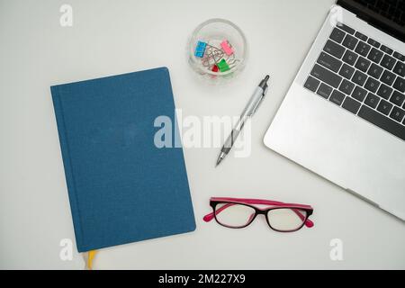 Bürobedarf Über Dem Schreibtisch Mit Tastatur Und Gläsern Und Kaffeetasse Für Die Fernarbeit, Verschiedene Schuleinrichtungen Mit Heißgetränken Und Brillen. Stockfoto