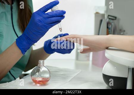 Frauenhände in einem Nagelsalon bei klassischer Maniküre - Nagelölbehandlung. Hand- und Nagelhautpflege. Maniküre und Pediküre und SPA. Stockfoto