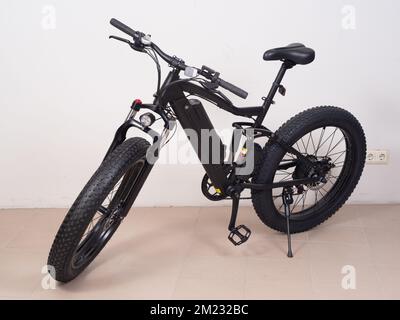 Modernes schwarzes Fahrrad mit dicken Rädern und Elektromotor. Stockfoto